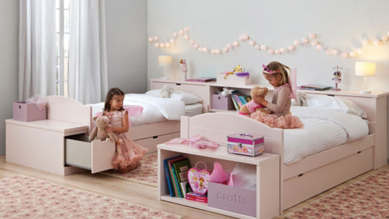 habitación infantil con dos camas nido en rosa y almacenamiento integrado