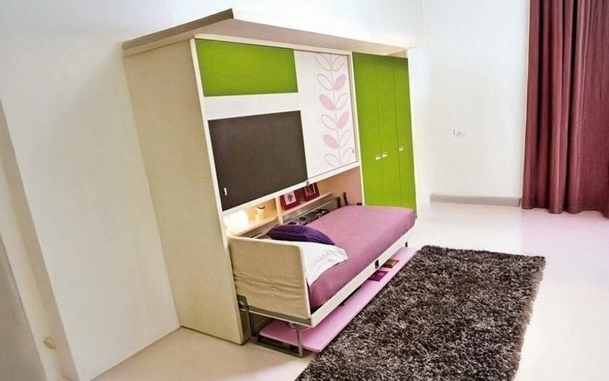 Mueble juvenil con cama abatible, escritorio frontal y armario superior.
