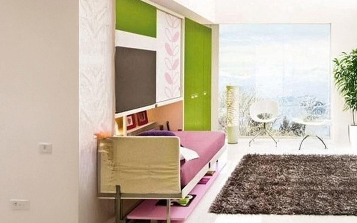 Mueble juvenil con cama abatible, escritorio frontal y armario superior.