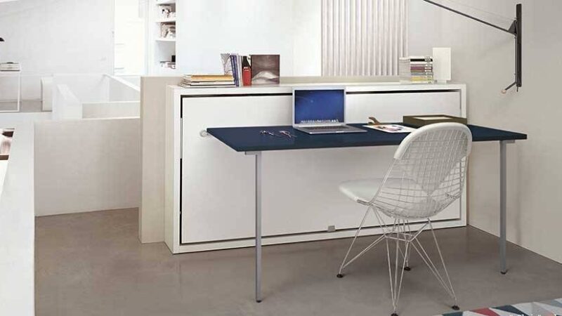 Mueble cama con escritorio ligero. Fácil abertura, requiere poco espacio. Mueble blanco con el sobre del escritorio azul marino.