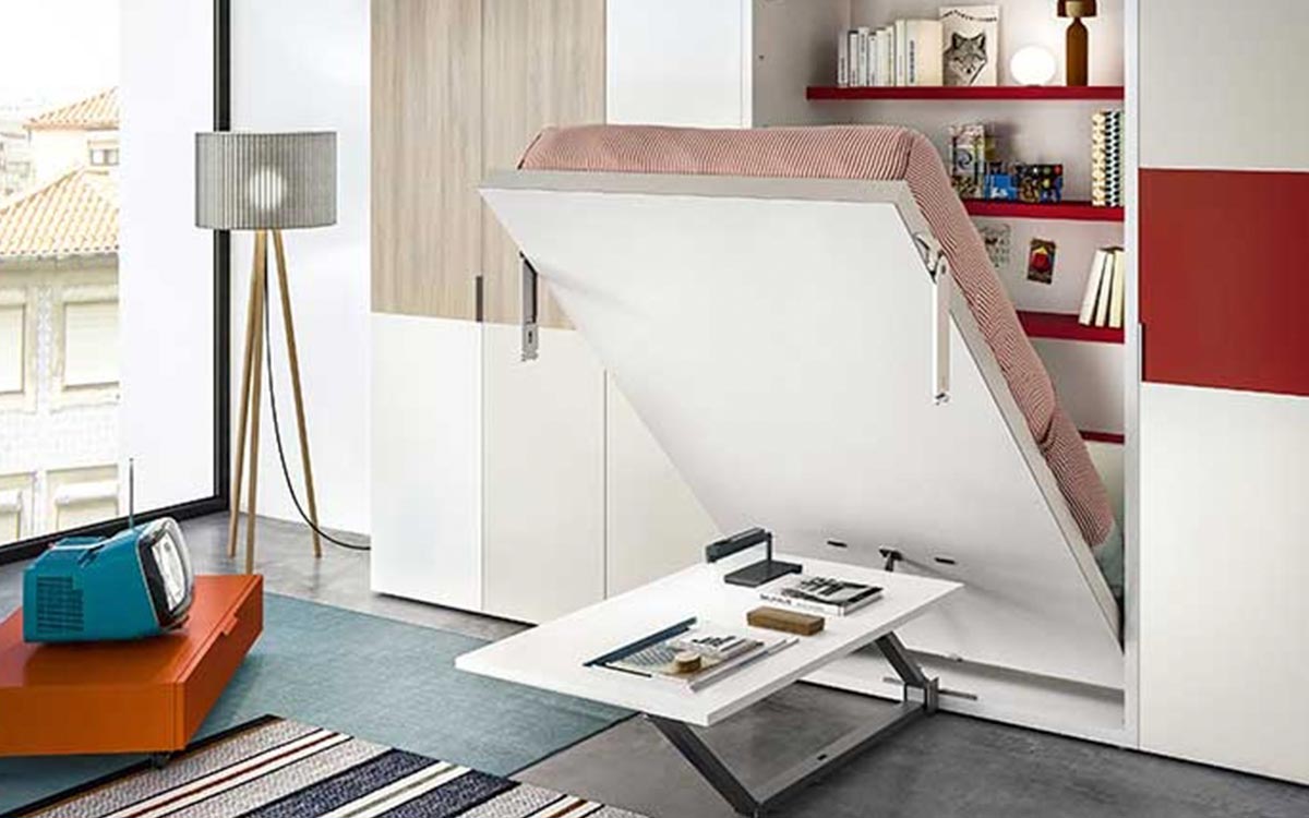 Cama abatible vertical con mesa funcional, diseño elegante y somier de lamas que optimiza el espacio en lofts y apartamentos pequeños.