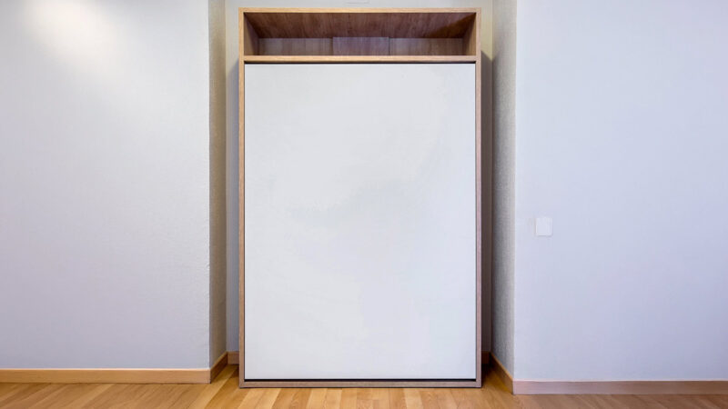 Cama abatible vertical individual con somier de madera, ideal para optimizar espacios y mantener la habitación ordenada.