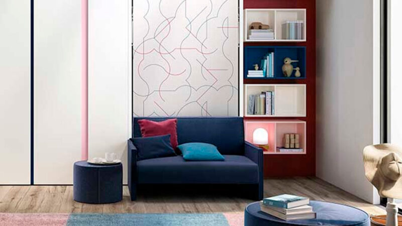 Cama abatible individual autoportante con sofá de espuma desenfundable y librería oculta integrada.