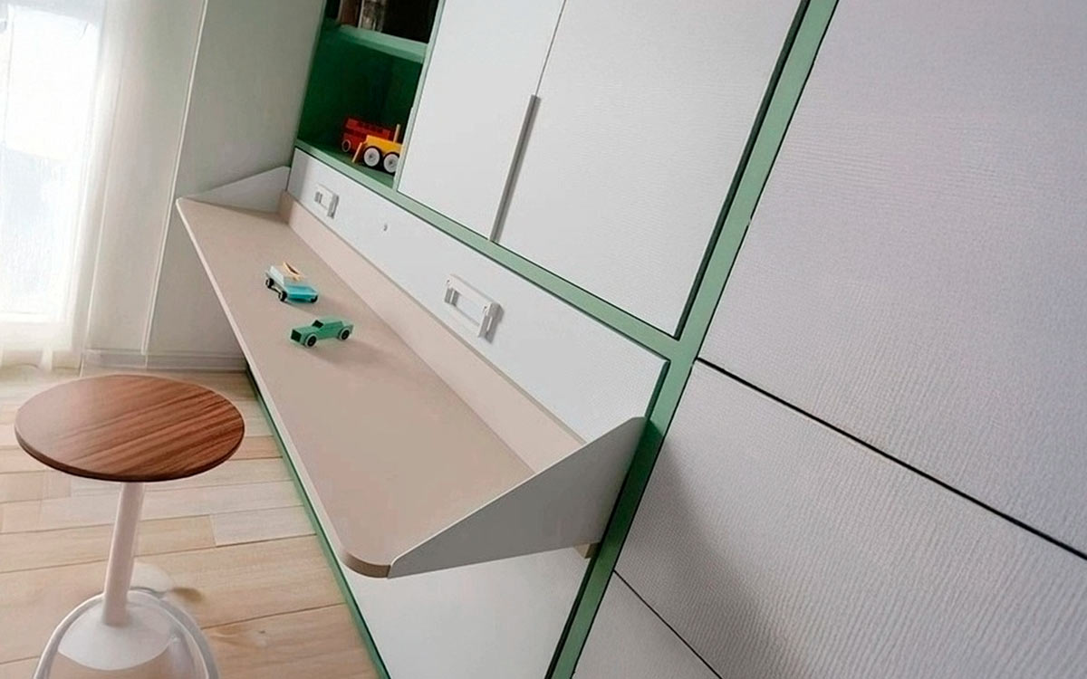 Cama abatible con mesa integrada y armario superior de gran capacidad.