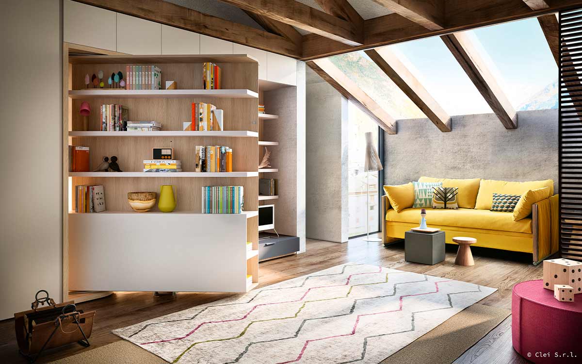 Cama de matrimonio giratoria con gran mesa y librería integradas.