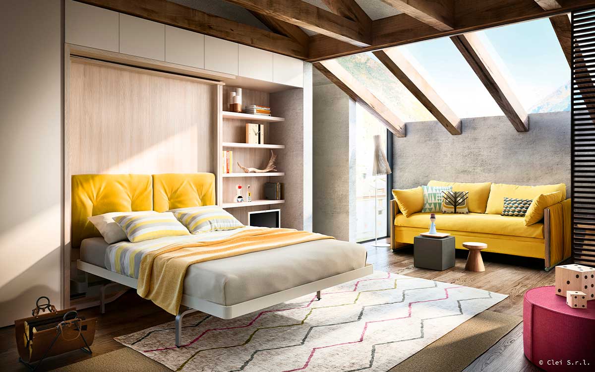 Cama de matrimonio giratoria con gran mesa y librería integradas.