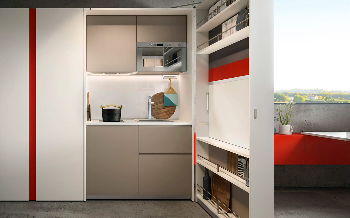 Módulo de cocina y comedor escamoteable con mesa y electrodomésticos integrados.