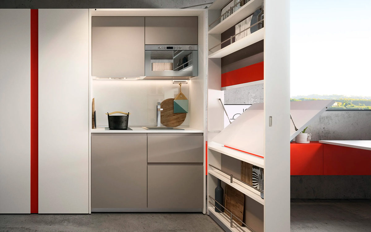 Módulo de cocina y comedor escamoteable con mesa y electrodomésticos integrados.