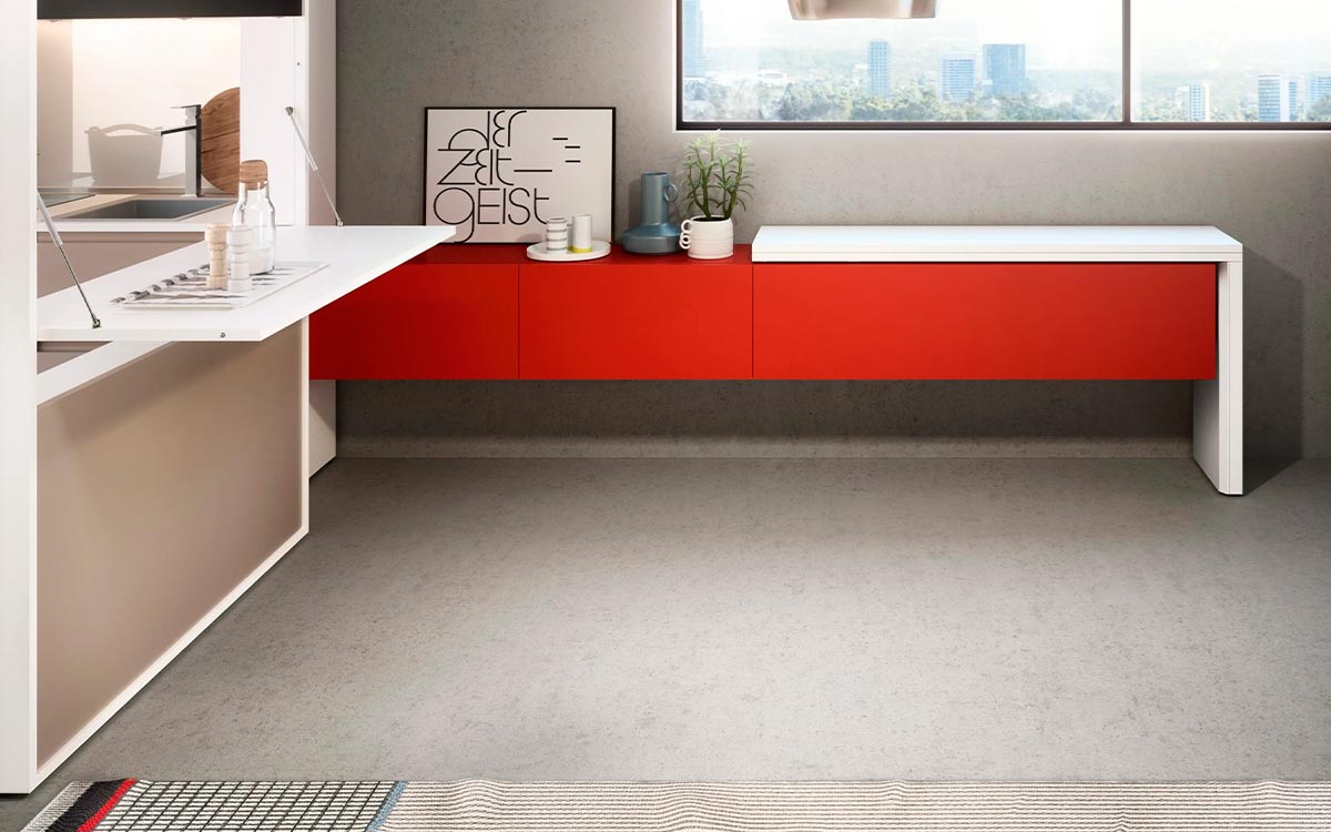 Módulo de cocina y comedor escamoteable con mesa y electrodomésticos integrados.