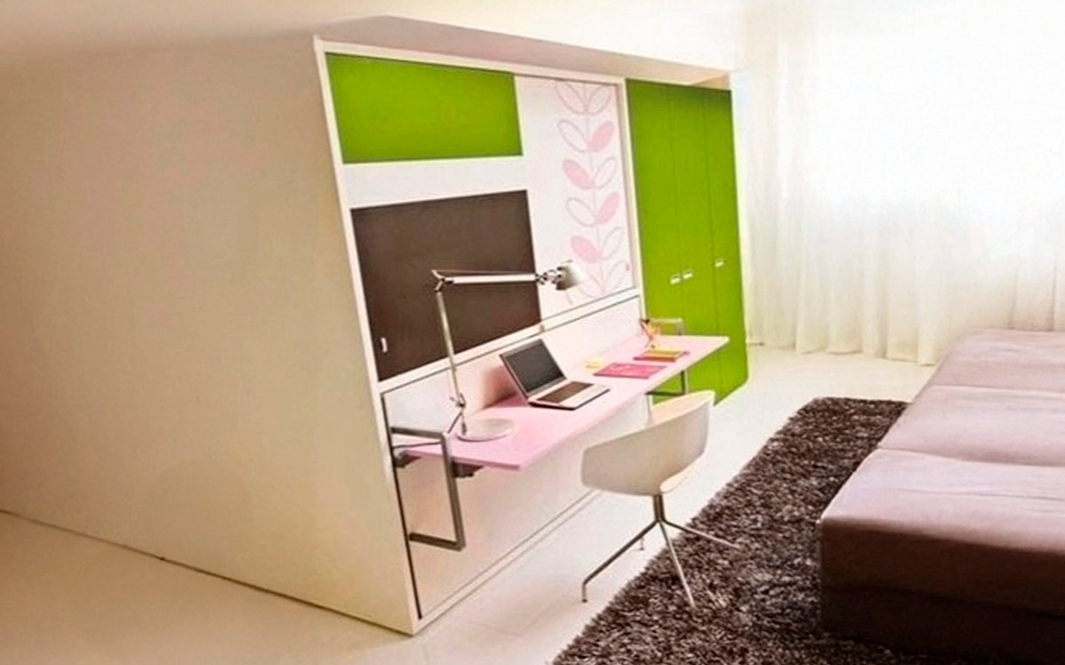 Mueble juvenil con cama abatible, escritorio frontal y armario superior.