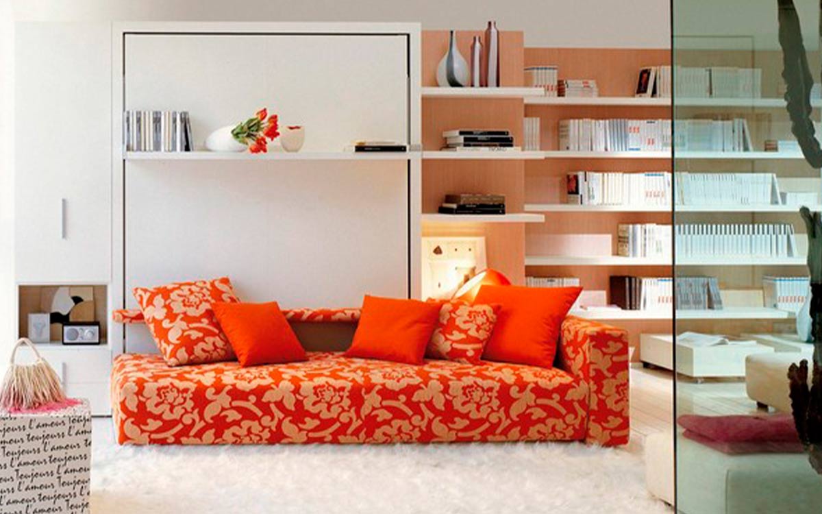 Mueble cama abatible de matrimonio con sofá diván delantero y estantería integrada.