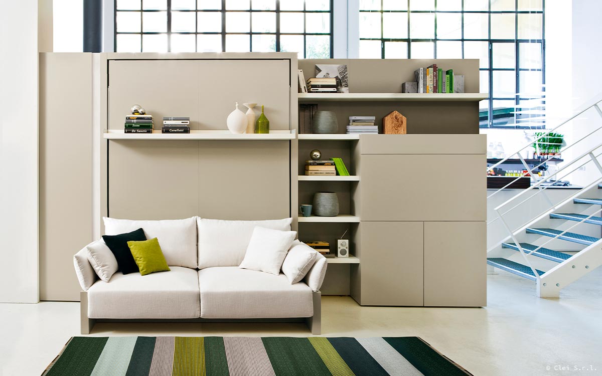 Mueble cama abatible con sofá arcón delantero y cómoda estantería integrada.