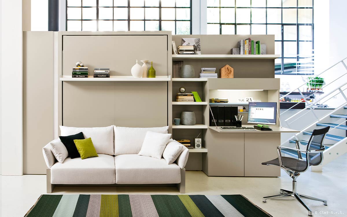 Mueble cama abatible con sofá arcón delantero y cómoda estantería integrada.