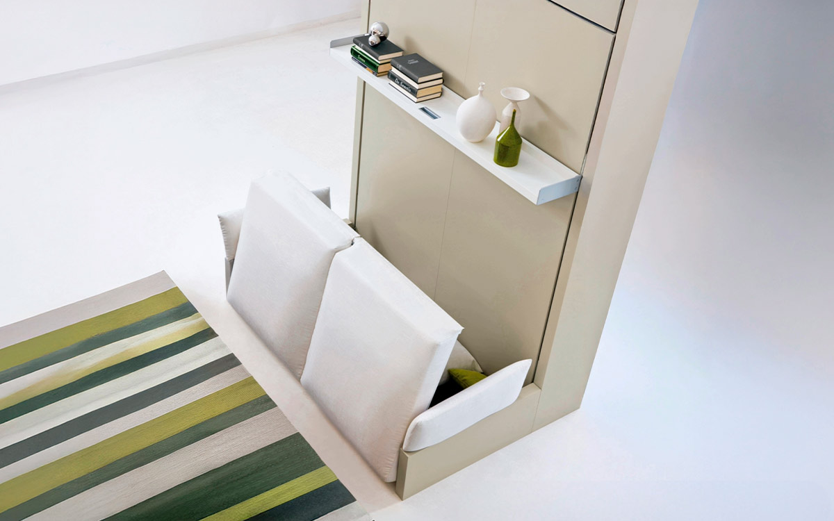 Mueble cama abatible con sofá arcón delantero y cómoda estantería integrada.