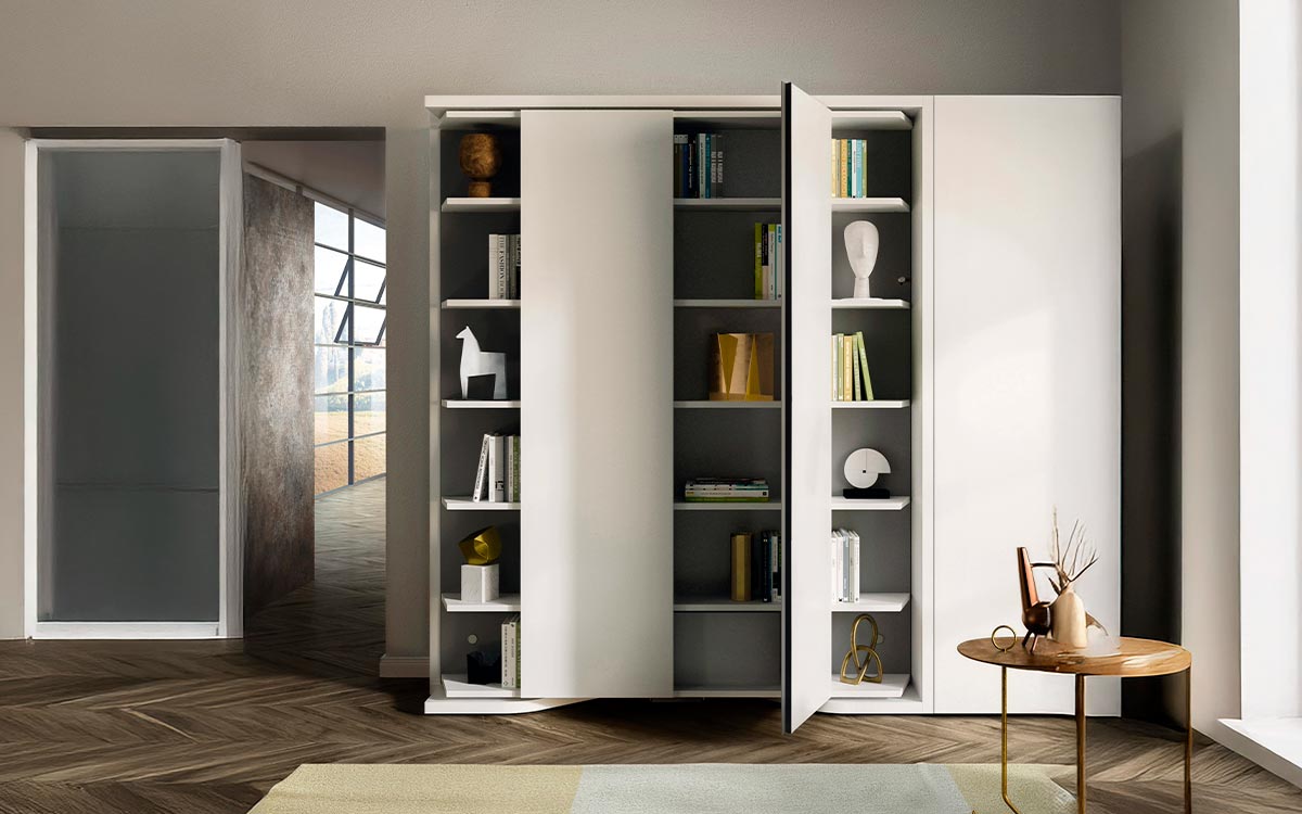 Mueble cama giratoria con librería y armario frontal integrados.