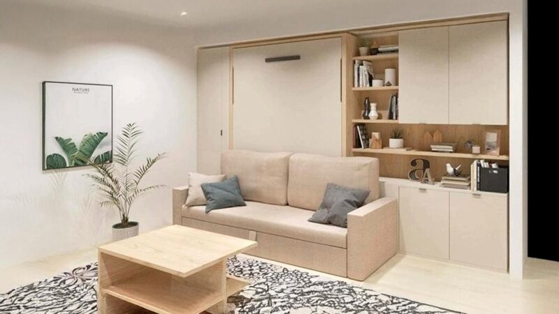 Cama abatible vertical de matrimonio con sofá y cómodo arcón integrado.