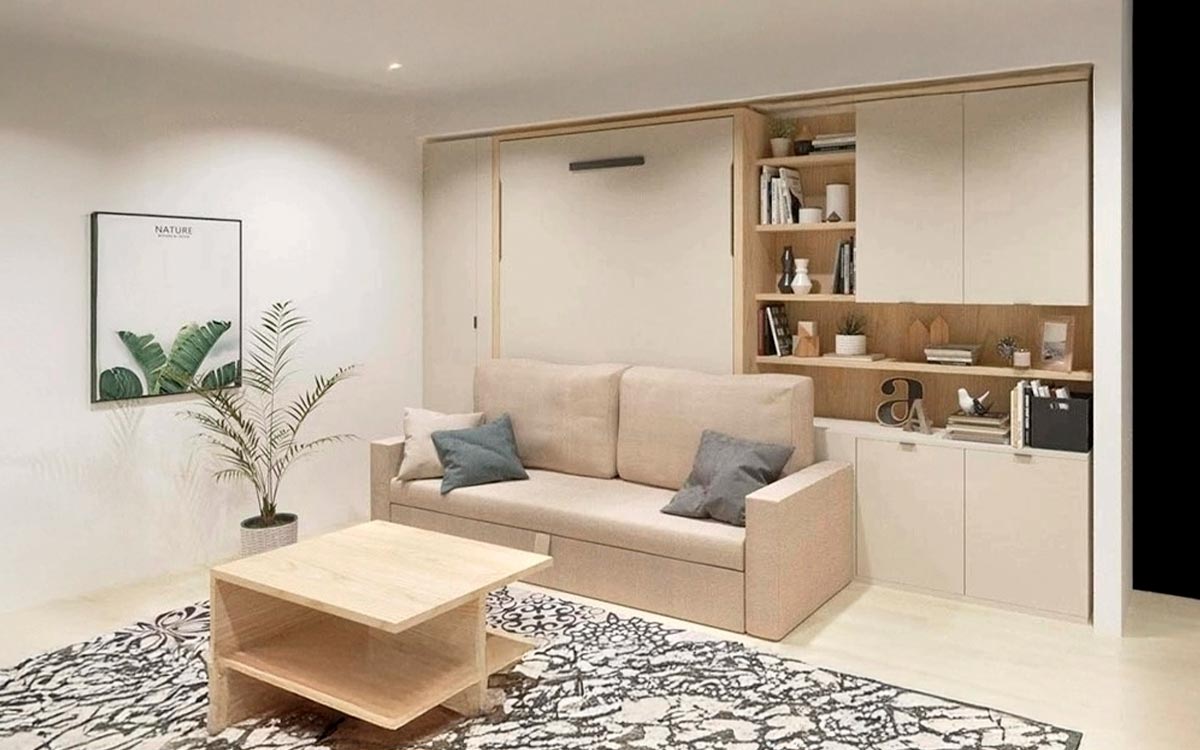 Cama abatible vertical de matrimonio con sofá y cómodo arcón integrado.